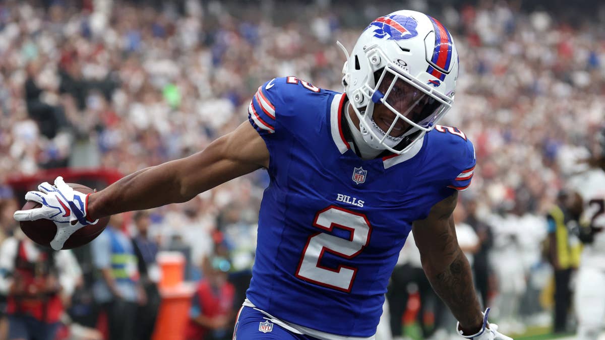 DJ Moore in a blue Bills jersey with number 2, holding a football.