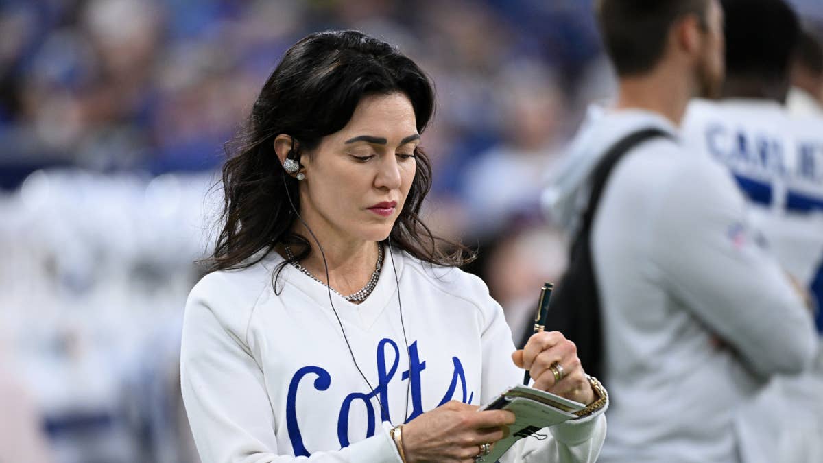 Carlie Irsay-Gordon in a white Colts sweatshirt with blue lettering, taking notes on a clipboard.