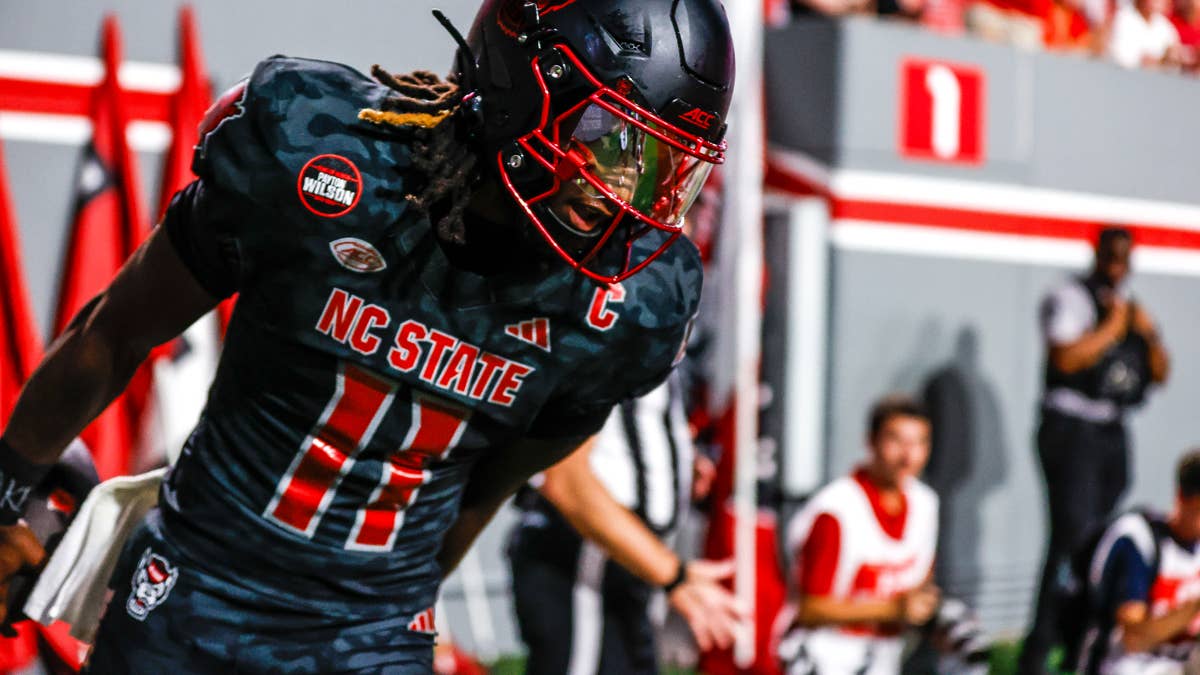 NC State quarterback CJ Bailey in black uniform with red numbers 10, red helmet with red face mask.