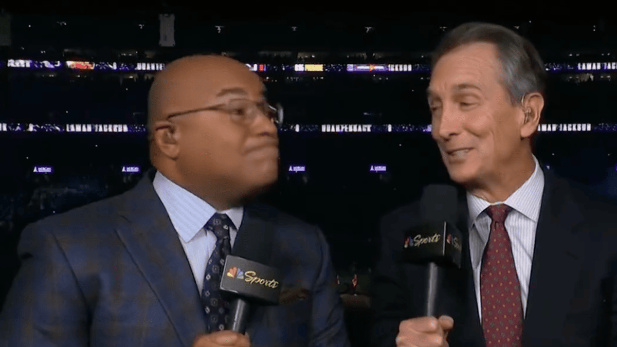 Cris Collinsworth and another man in suits with NBC Sports microphones in front of a stadium crowd.
