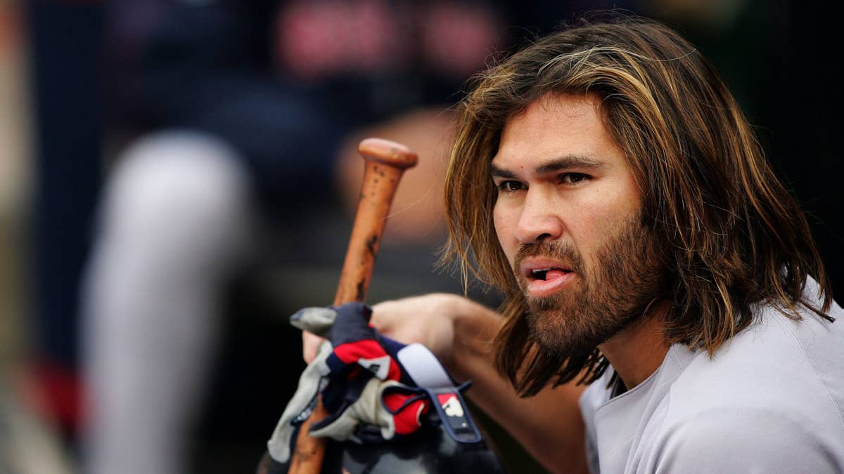 Johnny Damon in a grey jersey with a baseball bat and batting gloves.