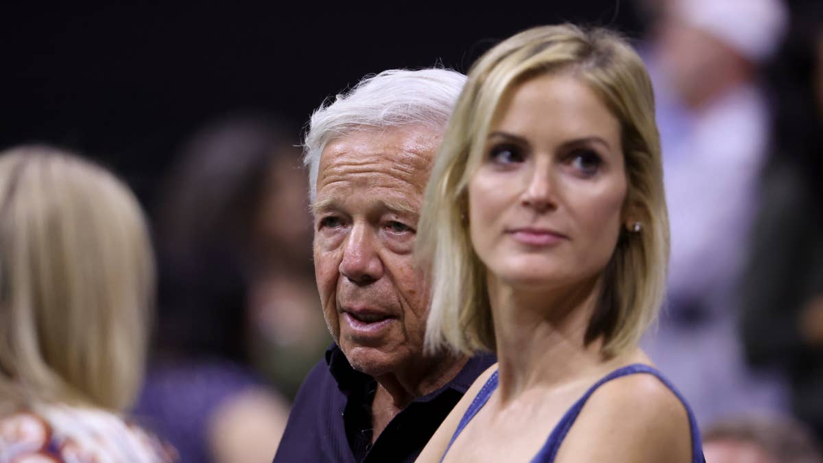 Robert Kraft in a dark shirt with a blonde woman in a blue top.
