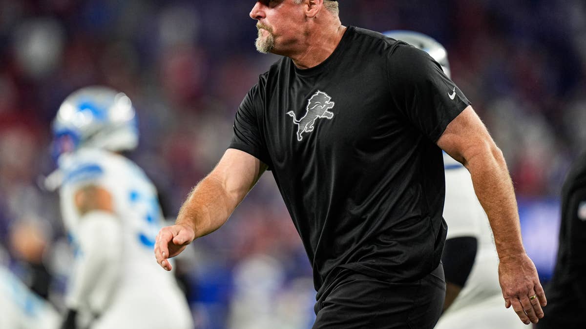 Detroit Lions coach Kelvin Sheppard in a black shirt with a lion logo on the field.