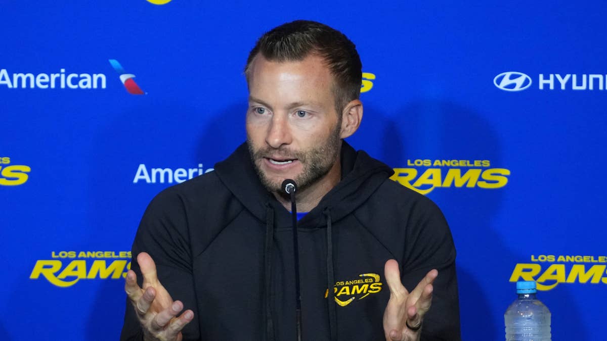 Sean McVay in a black hoodie with the Los Angeles Rams logo speaks at a podium.