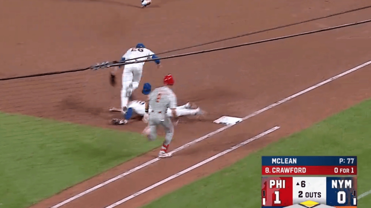 Jared Young in a grey Phillies uniform lies on the ground after a collision, while a player in a blue Dodgers uniform runs past.