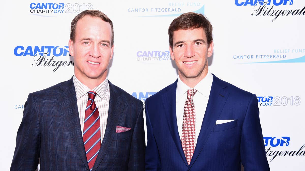 Peyton Manning and Eli Manning in suits at Cantor Charity Day 2016