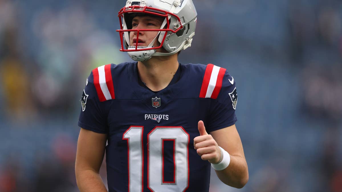 Drake Maye in Patriots #10 jersey gives a thumbs up on the field.