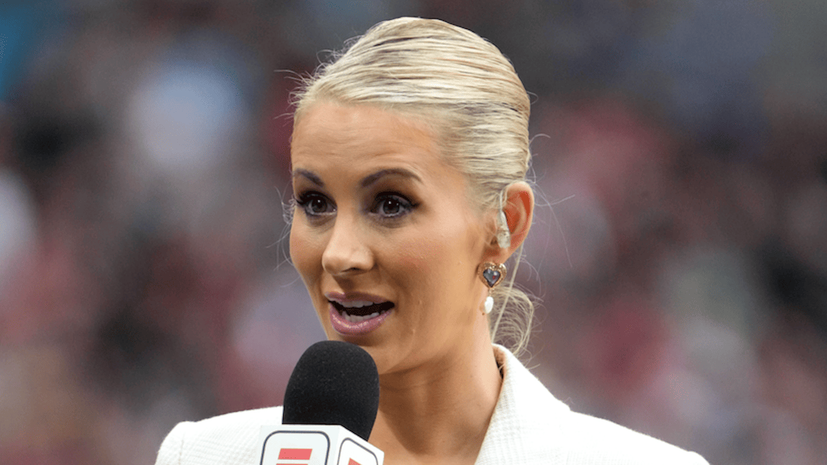 Laura Rutledge speaks into a microphone wearing a white blazer with an ESPN logo.