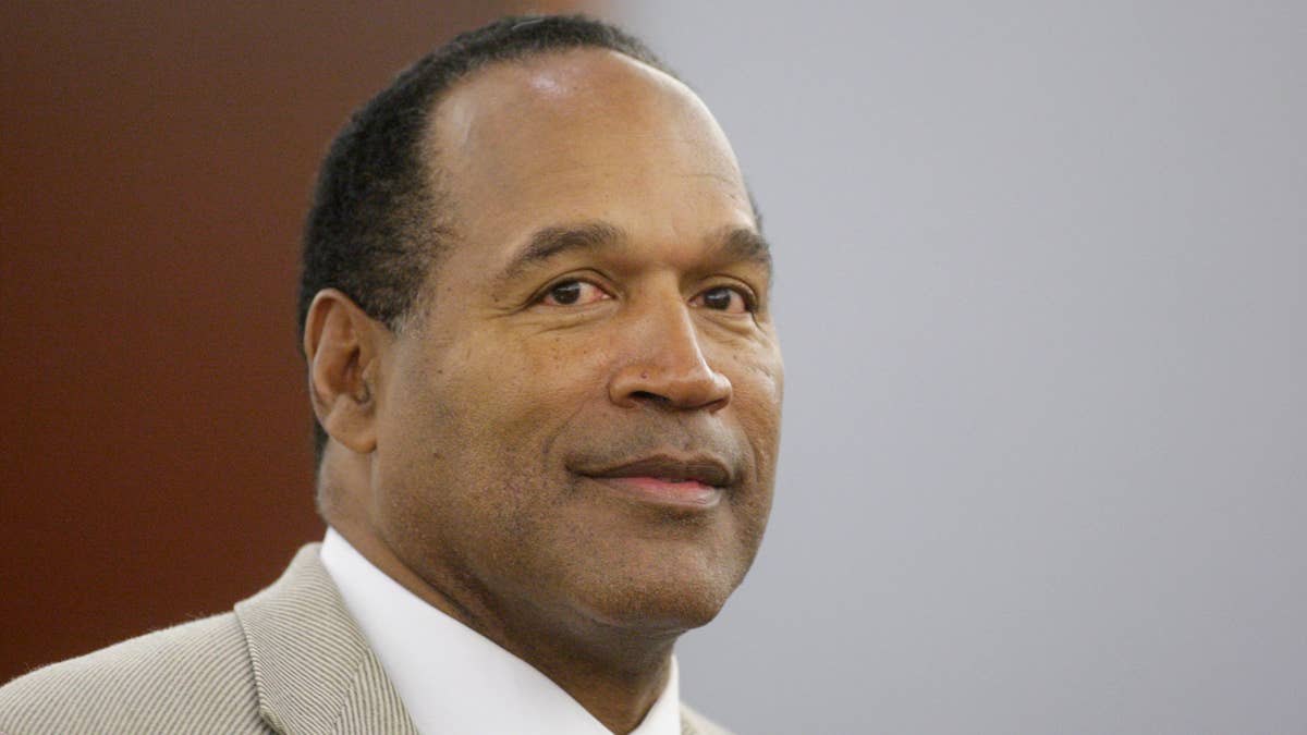 O.J. Simpson in a light pinstripe suit and white shirt.