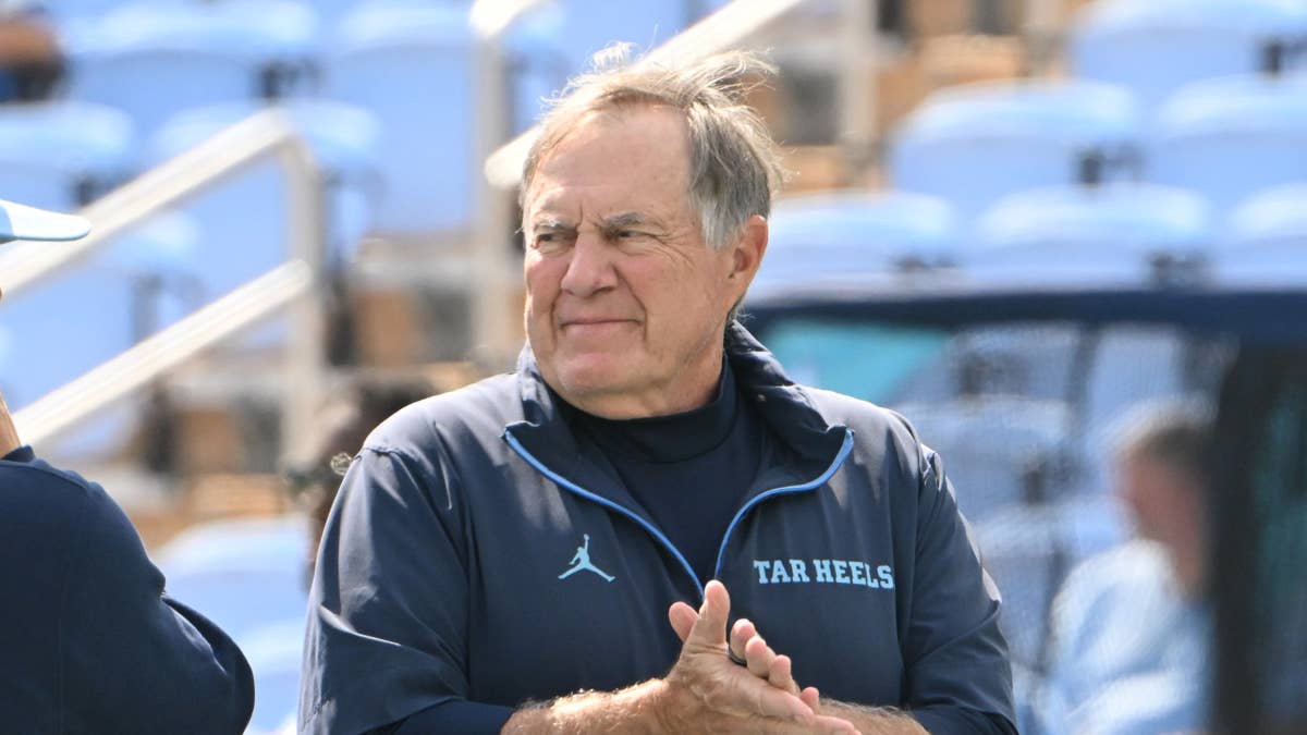 Bill Belichick in a navy Tar Heels jacket with a Jumpman logo and "TAR HEELS" text.