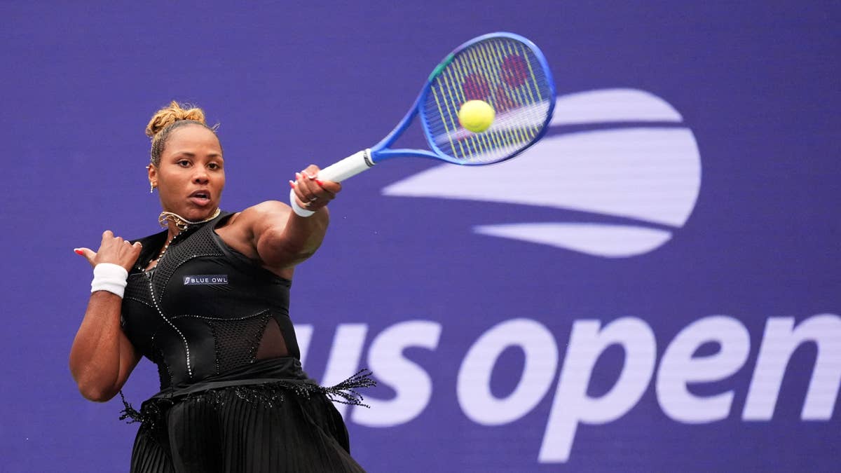 Taylor Townsend hits a tennis ball in a black outfit with "BLUE OWL" logo at the US Open.