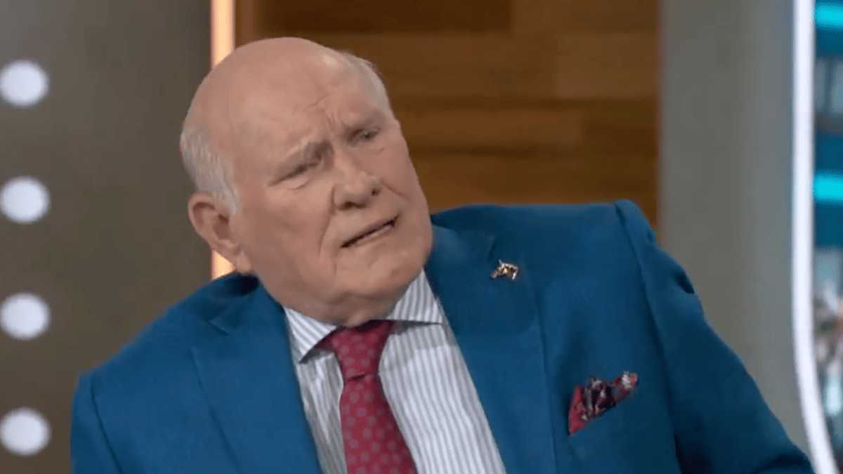 Terry Bradshaw in a blue suit, red tie, and striped shirt on FOX NFL Sunday.