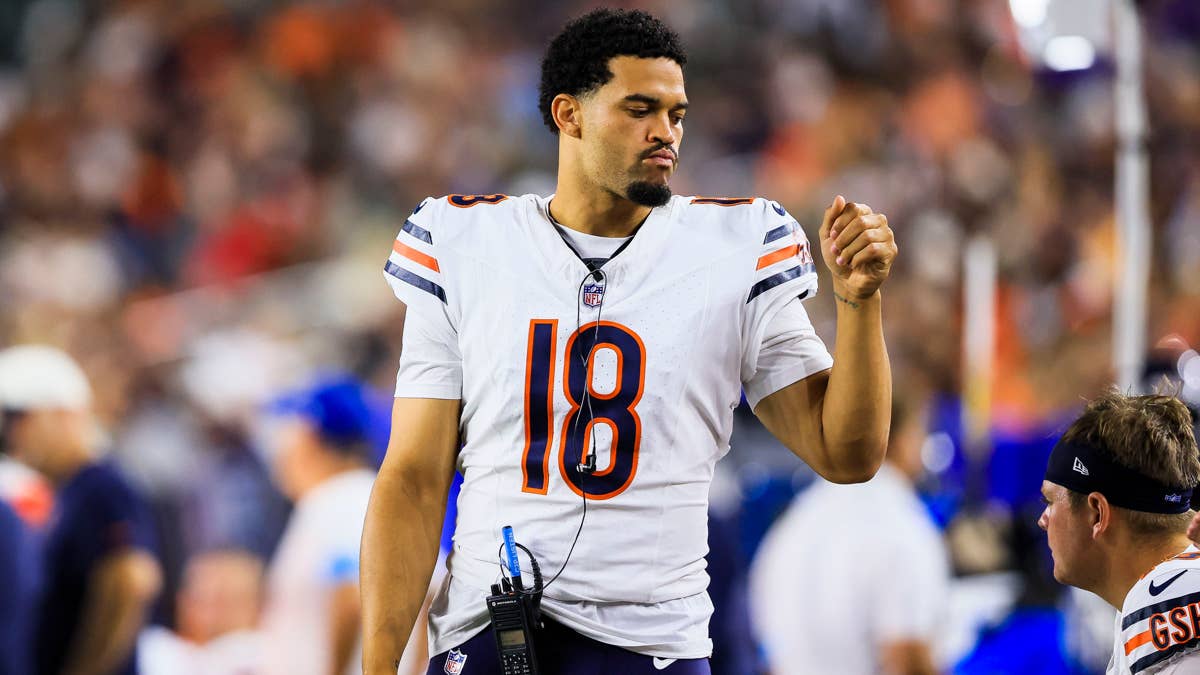 Caleb Williams in a white Chicago Bears jersey number 18, with a headset and radio, on the field.