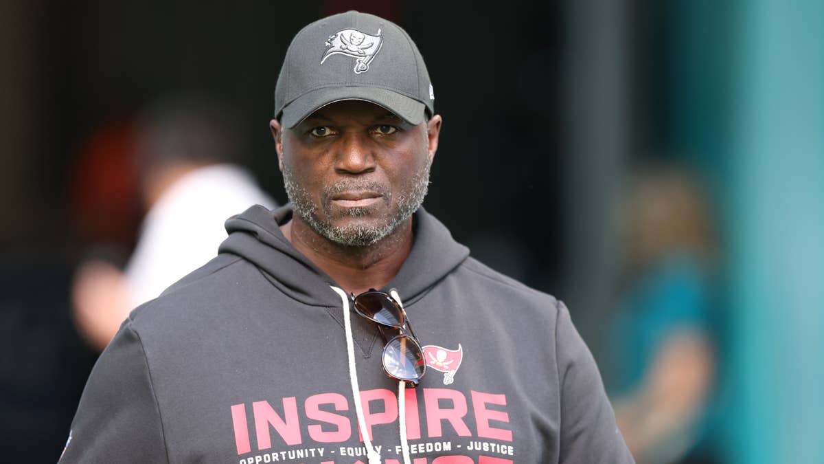 Todd Bowles wearing a gray Buccaneers cap and hoodie with "INSPIRE" text.